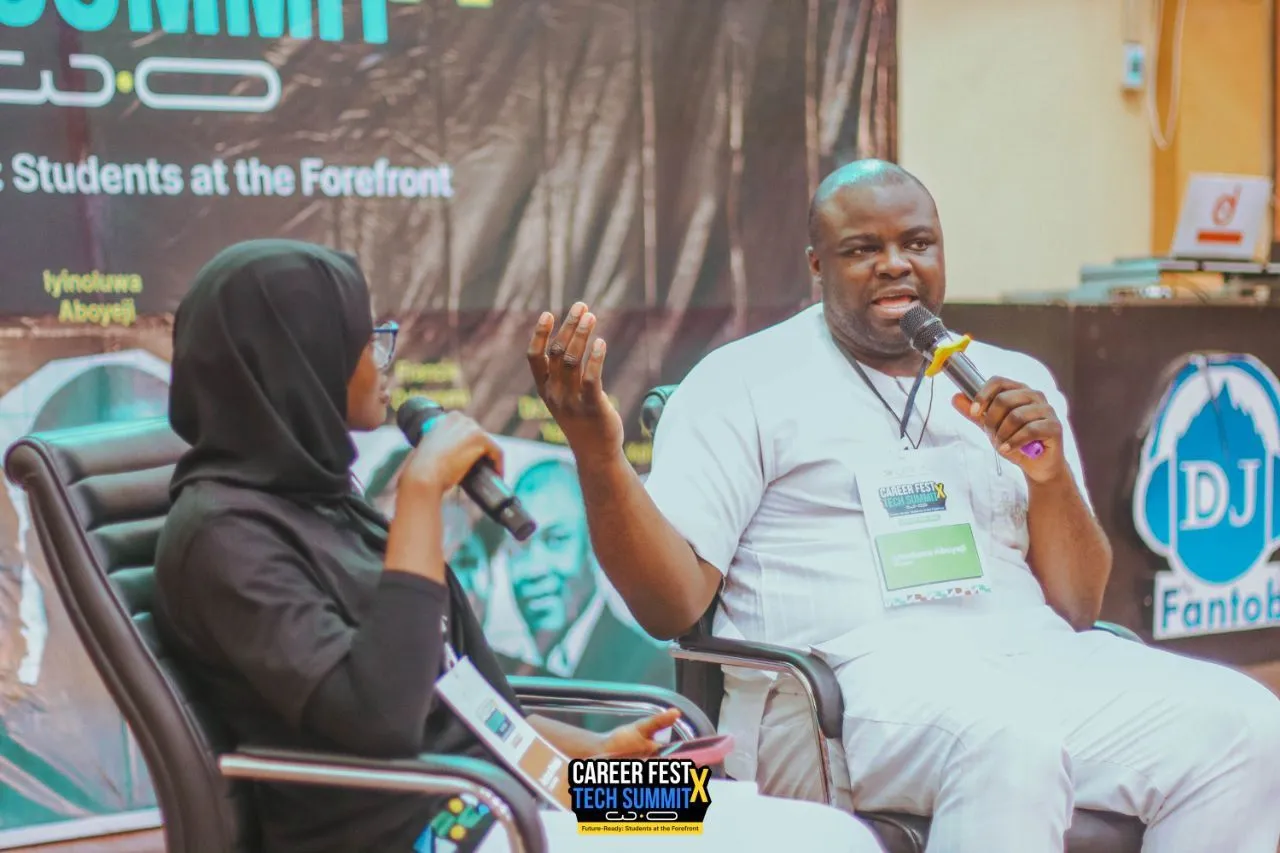 Aminat holding a microphone during a fireside chat with Iyinoluwa Aboyeji on the CareerFest X TechSummit stage